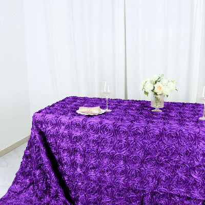 Purple rose tablecloth with elegant floral arrangement and wine glasses.