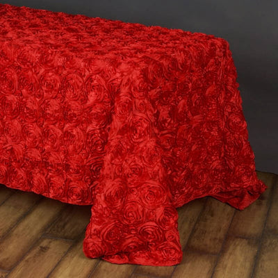 Red rose pattern tablecloth on a wooden floor.