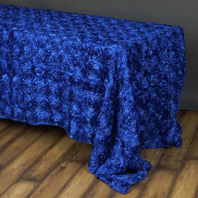 Blue rose-patterned tablecloth draping over a wooden surface.