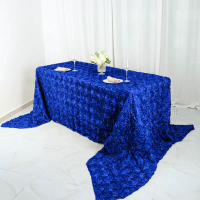Blue rose-patterned tablecloth draped over a table with floral centerpiece and glasses.