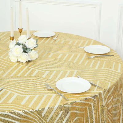 Gold striped tablecloth on a round table with white plates and floral centerpiece.