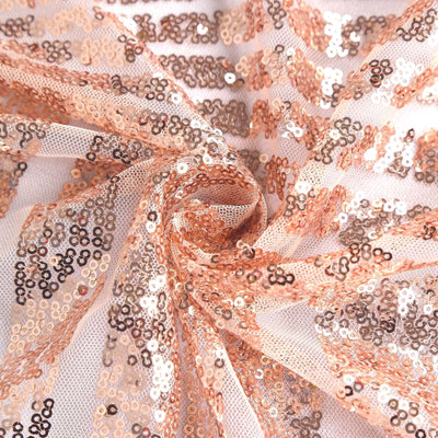 Rose gold sequin fabric with intricate patterns and texture details.