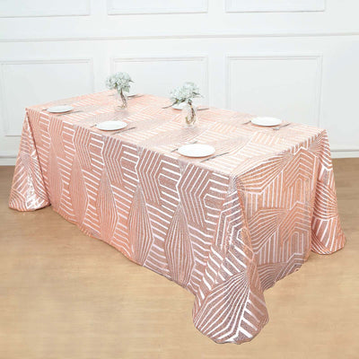 Rose gold sequin tablecloth on a dining table with plates and flowers.