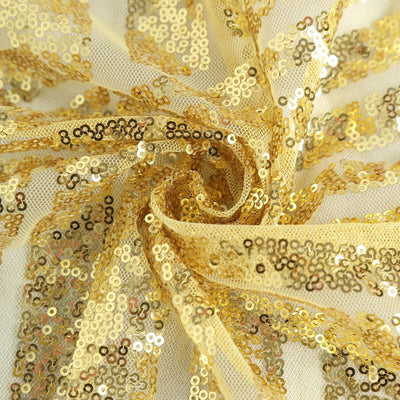 Gold sequin fabric twisted in a swirl pattern.