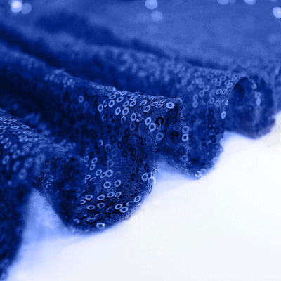 Blue sequin fabric draping elegantly on a white background.