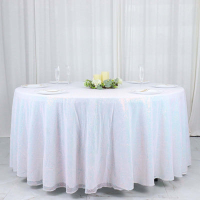 Round table covered with a sparkling white tablecloth and centerpiece.