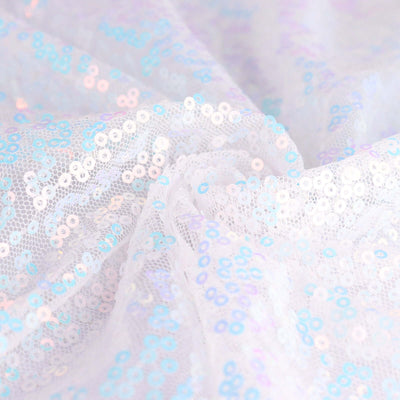 White fabric with iridescent sequins, showcasing a shimmering texture.