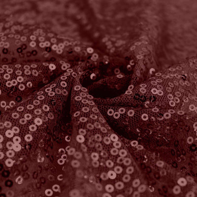 Burgundy sequin fabric with intricate texture and shine.