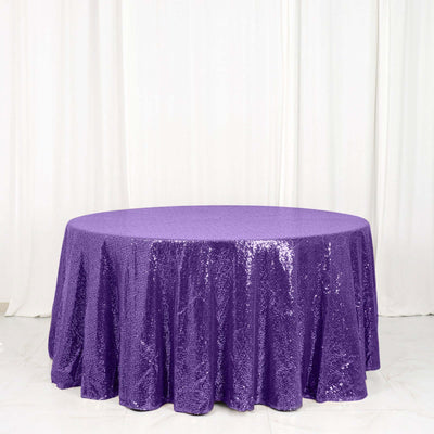 Purple sequin tablecloth on a round table against a white backdrop