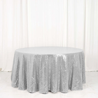 Round silver sequin tablecloth on a plain white backdrop