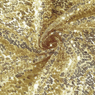 Gold sequin fabric with a shimmering texture in a swirling pattern.