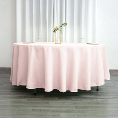 Pink tablecloth draped on a round table in a bright, airy setting.