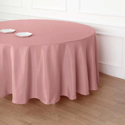 Round pink tablecloth draped elegantly over a table with plates on top.