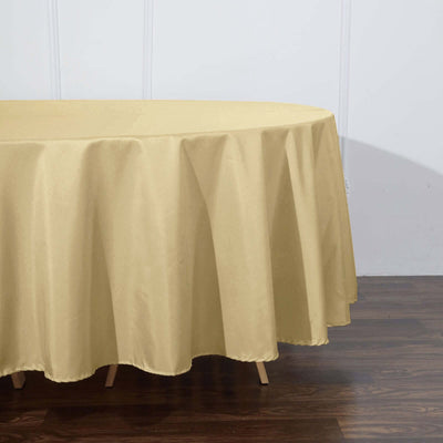Gold tablecloth draped over a round table in a studio setting.