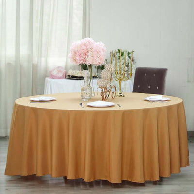 Round brown tablecloth draped on a table with floral centerpiece and tableware.