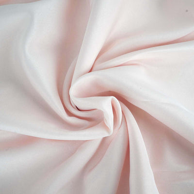 Soft pink fabric draped in gentle folds, showcasing its smooth texture.