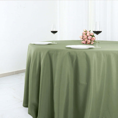 Elegant green tablecloth draped over a table with wine glasses and floral centerpiece.