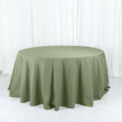 Round olive green tablecloth on a white backdrop.