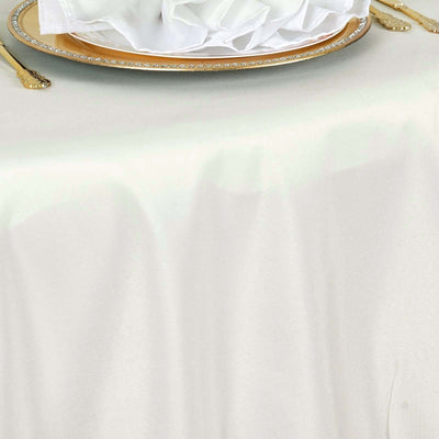 Elegant white tablecloth draped over a table with a decorative plate and napkin.