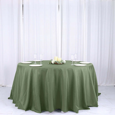 Olive green round tablecloth on a table with decorative centerpiece