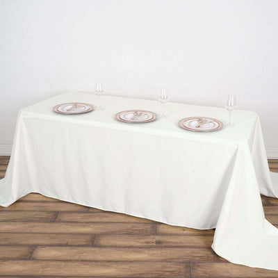 Elegant white table set for dinner with plates and glasses.