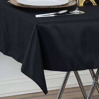 Black tablecloth draped over a table with elegant dining setup.
