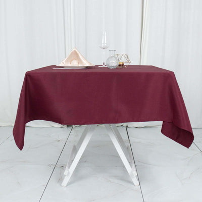 Burgundy tablecloth draped over a dining table with elegant settings.