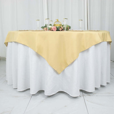 Elegant round table with a gold tablecloth and floral centerpiece.