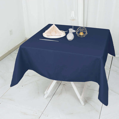 Navy blue tablecloth draped over a white table with decorative items.