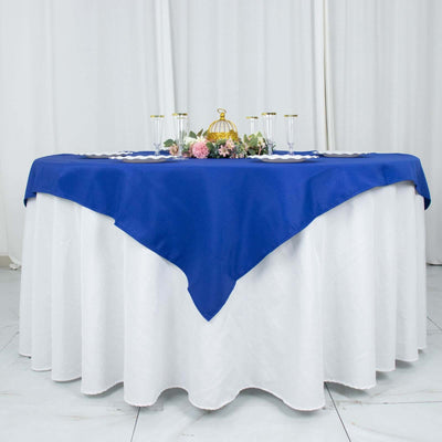 Blue tablecloth draped over a round table with decorative centerpieces
