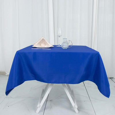 Blue tablecloth draped over a white table with glassware and napkin.