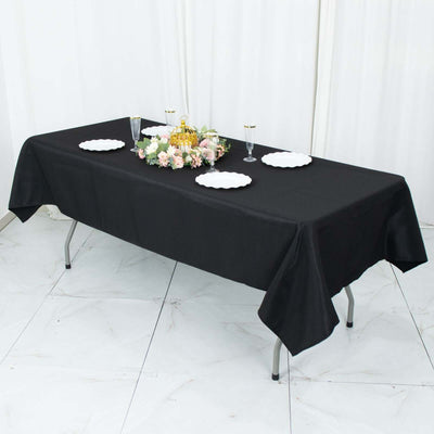 Black tablecloth draped over a table set for an elegant dining experience.