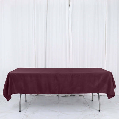 Burgundy tablecloth on a table with a plain white backdrop