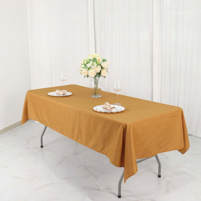 Elegant mustard tablecloth on a dining table with floral centerpiece and tableware.