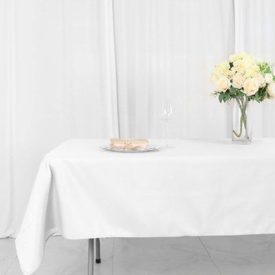 Elegant table setting with roses and wine glass on a white tablecloth.