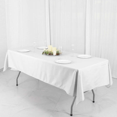 White table set with plates and candles for a dining setup.