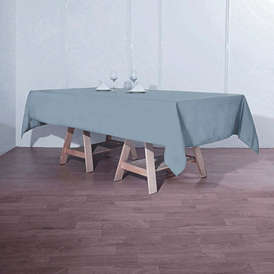 Gray tablecloth draped over a wooden table in a minimalistic setting.