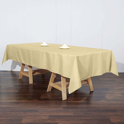 Beige tablecloth draped over a wooden table with decorative napkins.