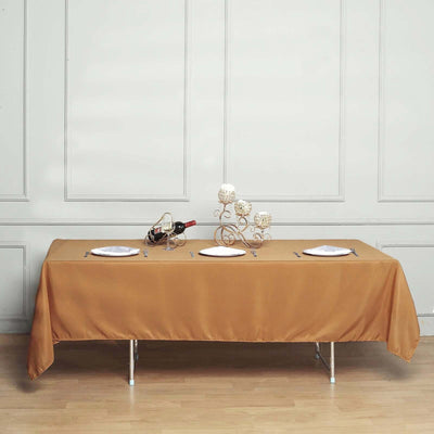 Elegant brown tablecloth draped over a dining table with plates and decor.