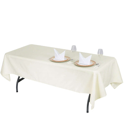 Beige tablecloth draped over a table set with plates and glasses