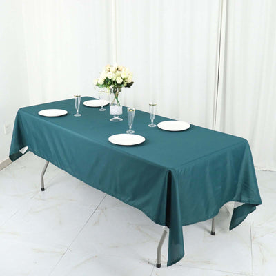 Teal tablecloth draped over a table set with plates and glasses.