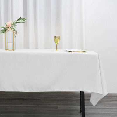 Elegant white table setting with a gold chalice and decorative plant.