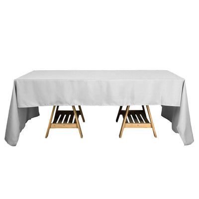 Gray tablecloth draped over a folding table with wooden legs.