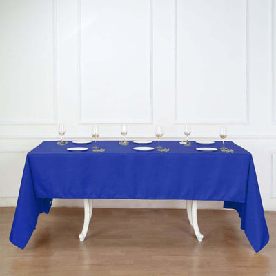 Blue tablecloth draped over a table with empty plates and glasses