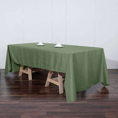 Green tablecloth draped over a wooden table with decorative napkins.