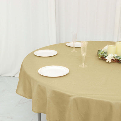 Elegant round table with a gold tablecloth and decorative plates.