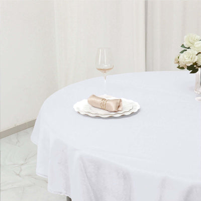 Elegant table setting with a napkin and wine glass on a white tablecloth.