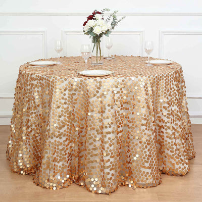 Gold sequin tablecloth on a round table with plates and glasses.
