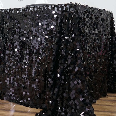 Black sequin tablecloth draped over a table, shimmering and elegant.