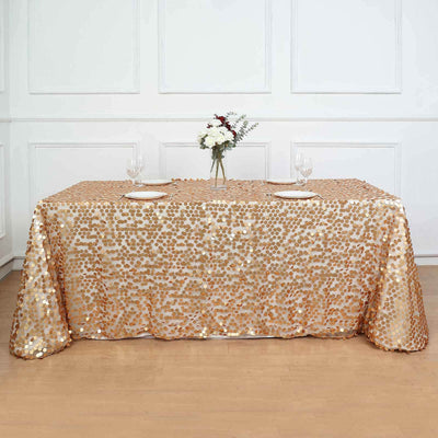 Gold sequin tablecloth draped elegantly on a table with floral centerpiece.
